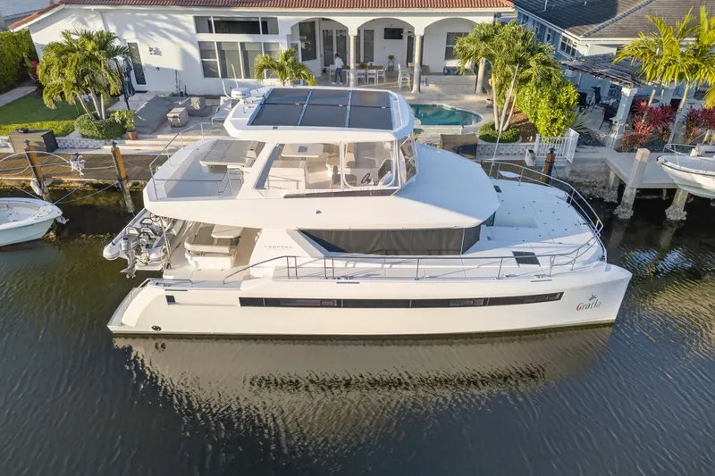 Slide: The Image of 2024 Leopard 46 Powercat yacht docked by a luxurious waterfront home. - 107