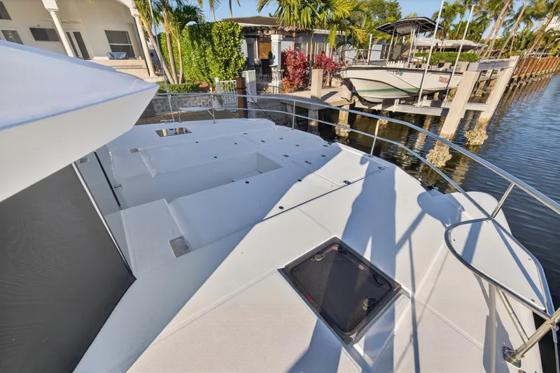 Slide: The Image of 2024 Leopard 46 Powercat yacht deck with sleek design, docked by waterfront homes. - 14