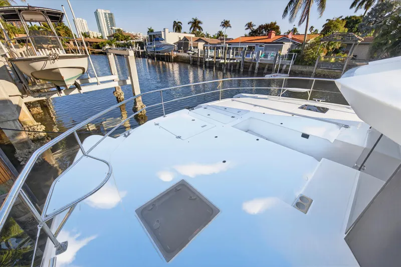 Slide: The Image of 2024 Leopard 46 Powercat yacht deck with waterfront view, palm trees, and modern architecture. - 15