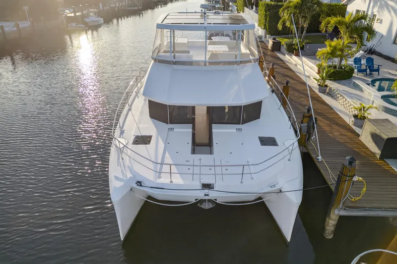 Slide: The Image of 2024 Leopard 46 Powercat yacht docked in a serene marina setting. - 2