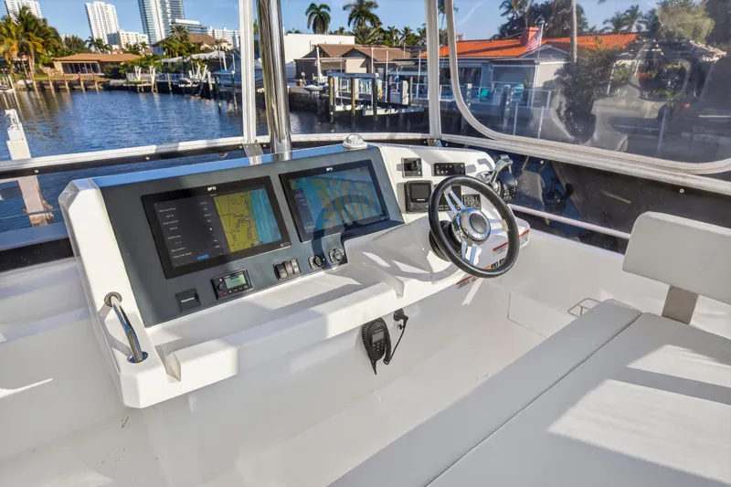Slide: The Image of 2024 Leopard 46 Powercat helm with modern navigation screens and steering wheel, dockside view. - 21
