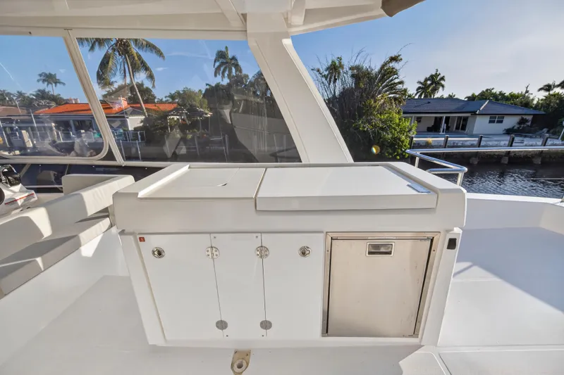 Slide: The Image of 2024 Leopard 46 Powercat yacht deck with outdoor kitchen and scenic waterfront view. - 29