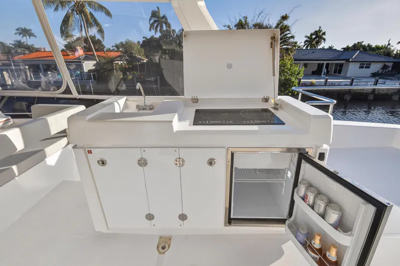 Slide: The Image of Outdoor kitchen on 2024 Leopard 46 Powercat with sink, stove, and mini fridge. - 30