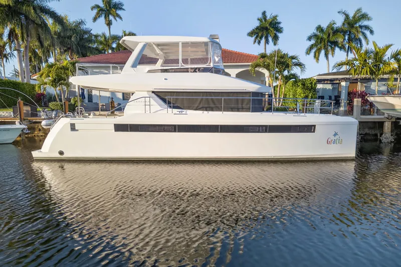 Slide: The Image of 2024 Leopard 46 Powercat yacht docked by palm trees and waterfront homes. - 5