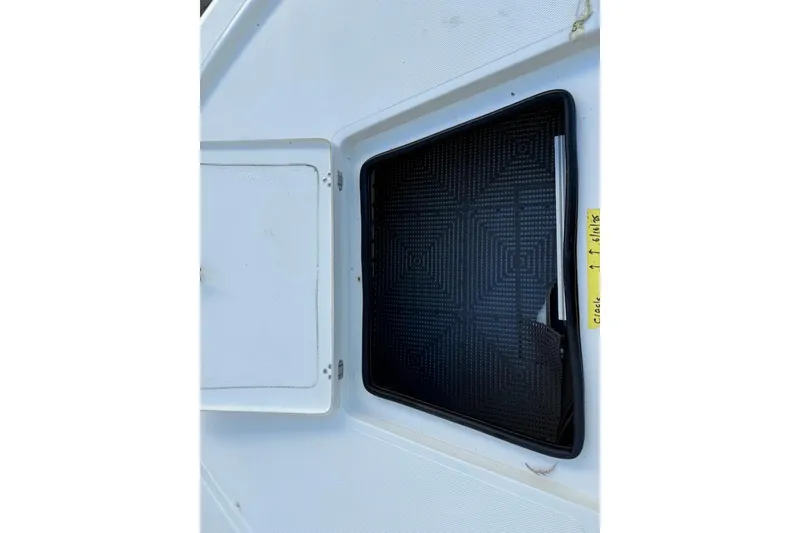 Slide: The Image of 2024 Mako 18 LTS boat hatch with textured black mat and open compartment. - 21
