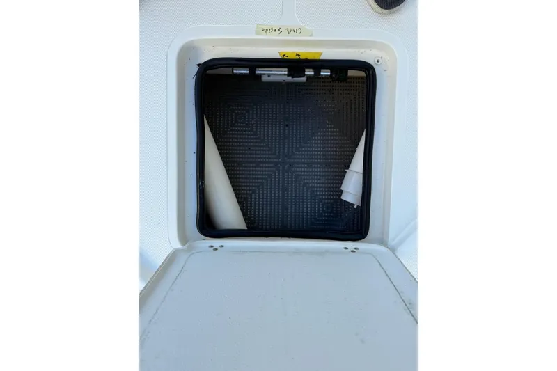 Slide: The Image of 2024 Mako 18 LTS boat storage compartment with textured interior and rolled-up material. - 4