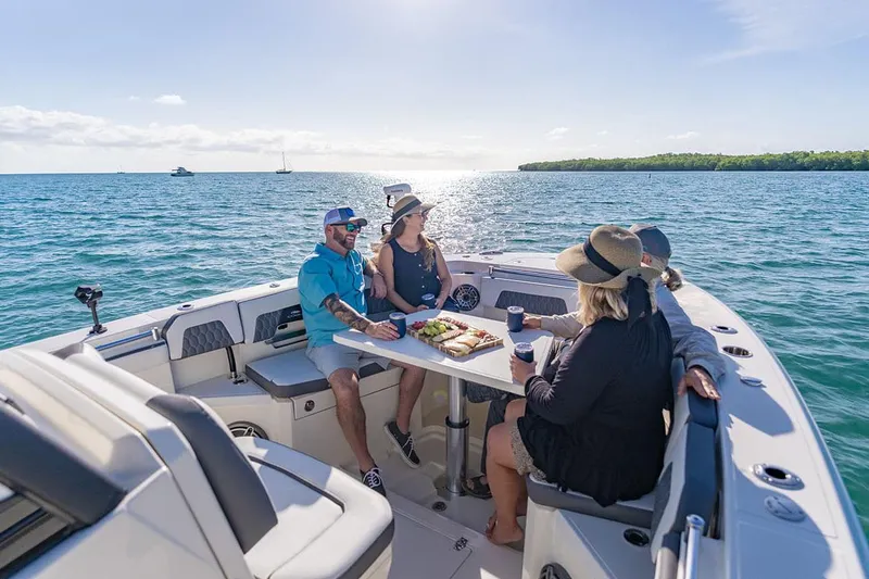 Slide: The Image of Manufacturer Provided Image: People enjoying a meal on a 2026 Cobia 305 Center Console boat. - 5