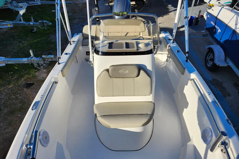 Slide: The Image of 2022 Key West 189 FS boat interior with seating and console, parked on a trailer. - 18
