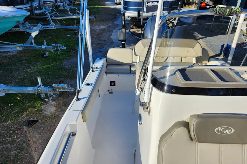 Slide: The Image of 2022 Key West 189 FS boat interior with seating and console, parked near trailers. - 20