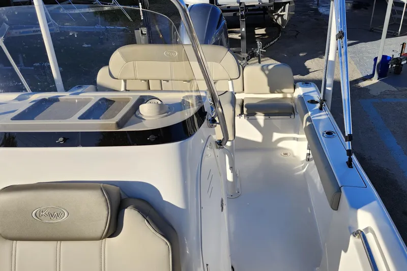 Slide: The Image of 2022 Key West 189 FS boat interior with seating and console, docked outdoors. - 21