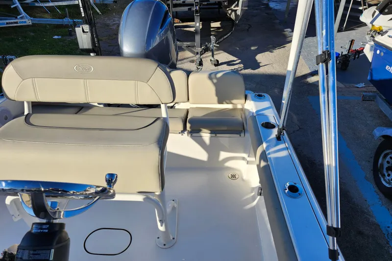 Slide: The Image of 2022 Key West 189 FS boat interior with beige seating and fishing rod holders. - 22
