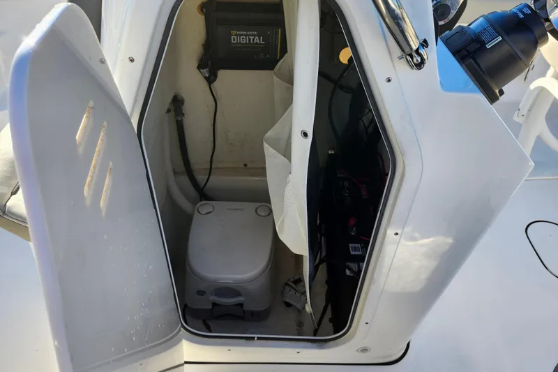 Slide: The Image of 2022 Key West 189 FS boat storage compartment with portable toilet and digital equipment. - 34