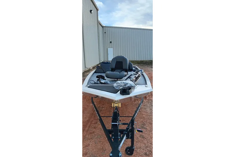 Slide: The Image of 2026 Tracker Pro 170 boat on trailer, parked beside a metal building. - 17