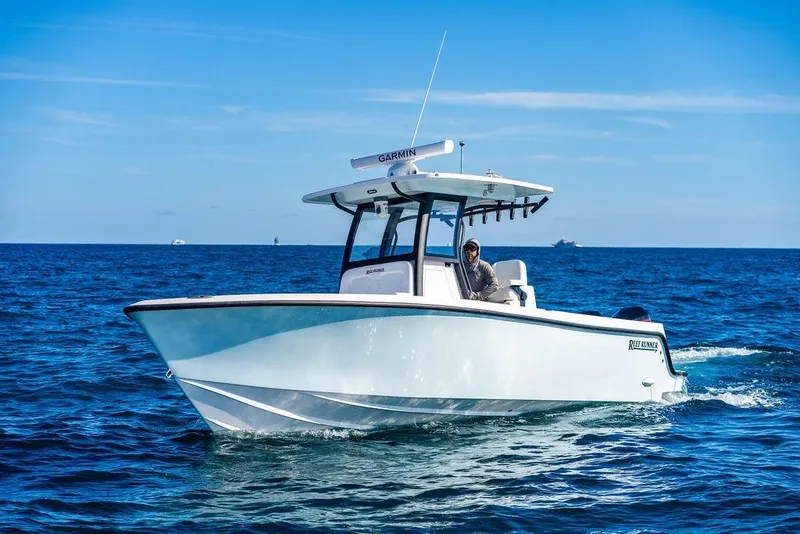 Slide: The Image of 2026 Reef Runner 280 boat cruising on open ocean under clear blue sky. - 10