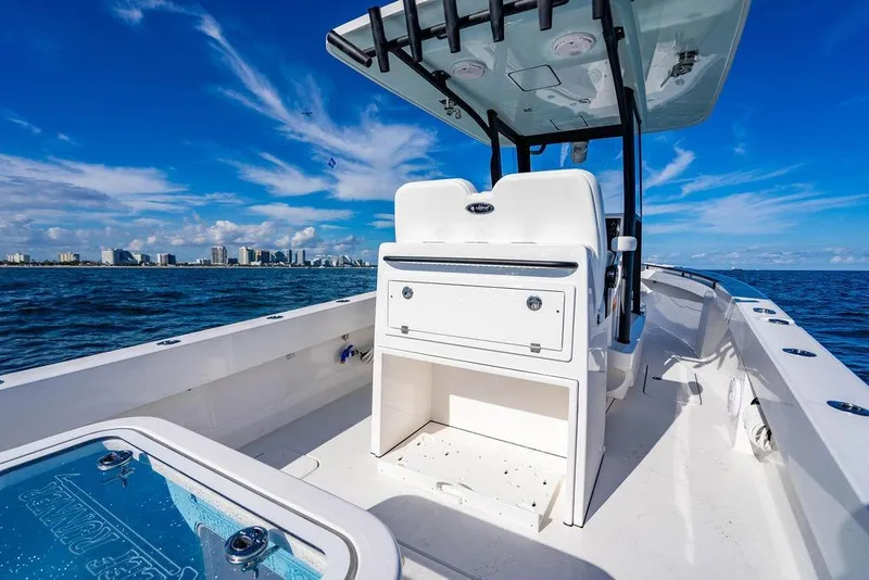 Slide: The Image of 2026 Reef Runner 280 boat on open water, clear sky, city skyline in background. - 17
