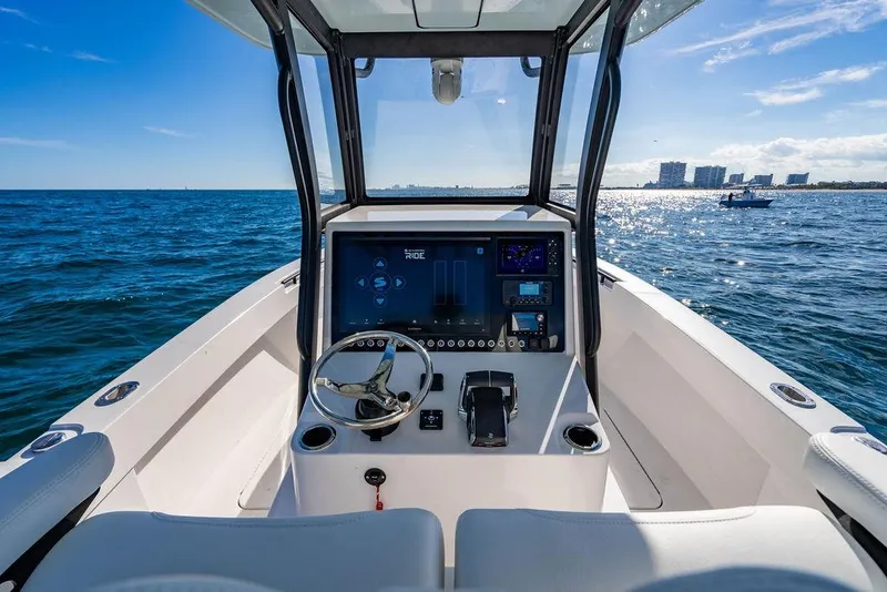 Slide: The Image of 2026 Reef Runner 280 boat cockpit with modern controls, steering wheel, and ocean view. - 18
