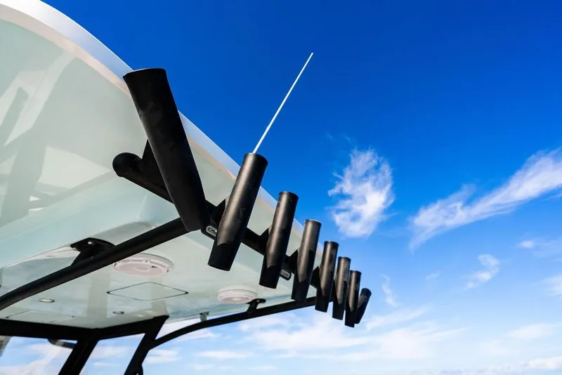 Slide: The Image of Fishing rod holders on a 2026 Reef Runner 280 boat under a clear blue sky. - 25