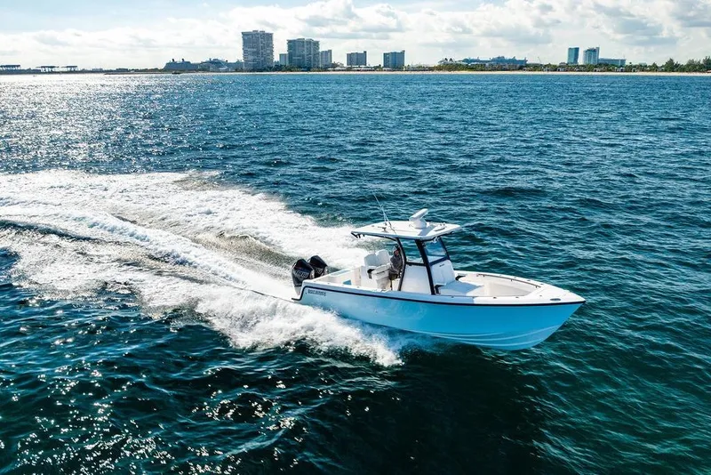 Slide: The Image of 2026 Reef Runner 280 boat cruising on open water near city skyline. - 31