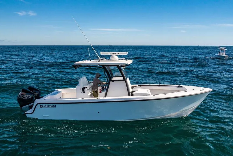 Slide: The Image of 2026 Reef Runner 280 boat cruising on open ocean under clear blue sky. - 8