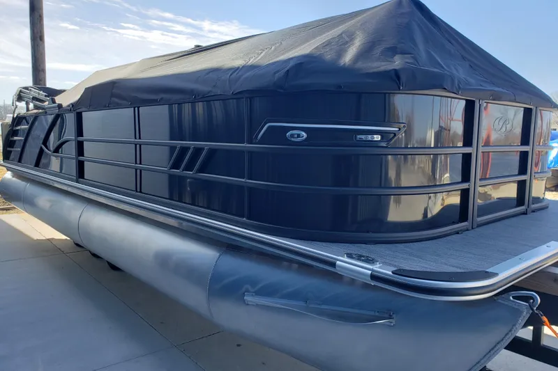 Slide: The Image of 2026 Bentley Pontoons Elite 253 Swingback Bench, covered and docked, side view. - 7