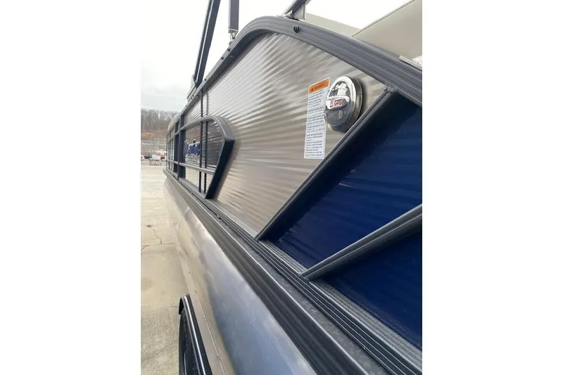 Slide: The Image of 2026 Manitou 25 Encore SL SHP pontoon boat side view, showcasing sleek design details. - 11