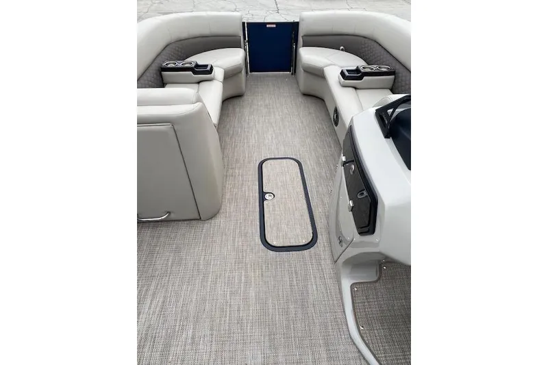Slide: The Image of 2026 Manitou 25 Encore SL SHP boat interior with beige seating and carpeted floor. - 14