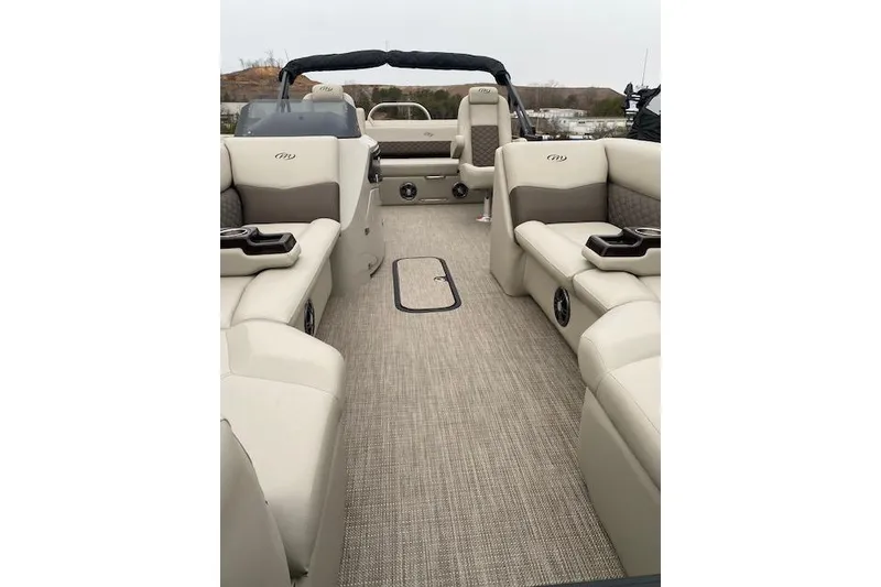 Slide: The Image of 2026 Manitou 25 Encore SL SHP pontoon boat interior with beige seating and carpet. - 15