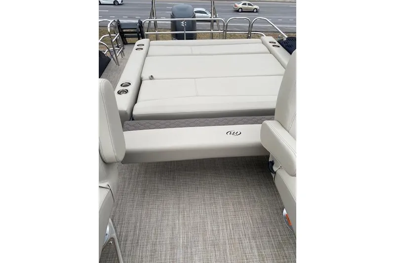 Slide: The Image of 2026 Manitou 25 Encore SL SHP boat interior with cushioned seating and cup holders. - 16