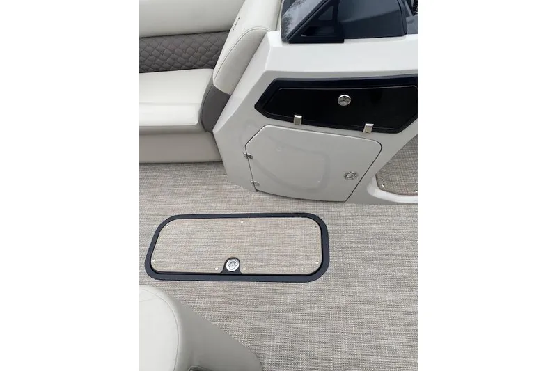 Slide: The Image of Interior of 2026 Manitou 25 Encore SL SHP boat, featuring seating and storage compartments. - 17
