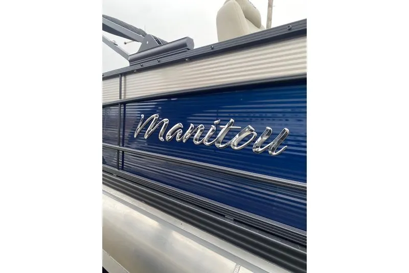 Slide: The Image of 2026 Manitou 25 Encore SL SHP boat with sleek blue and silver design. - 9