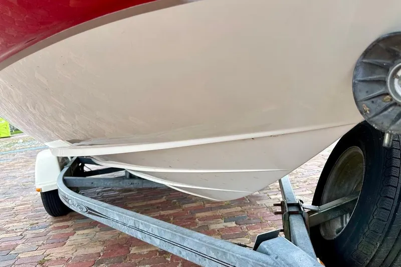 Slide: The Image of 2004 Sea Ray 200 Sundeck boat on trailer, showing hull and wheel detail. - 16