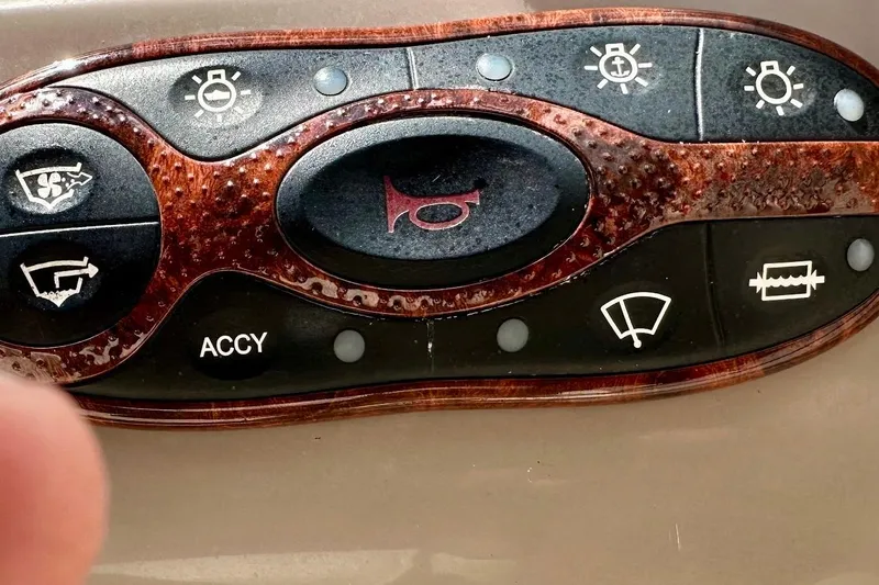 Slide: The Image of Control panel of a 2004 Sea Ray 200 Sundeck boat with various function buttons. - 6