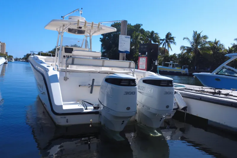 Slide: The Image of 2006 Century 3200 Center Console boat with twin Suzuki 300 engines docked by palm trees. - 12
