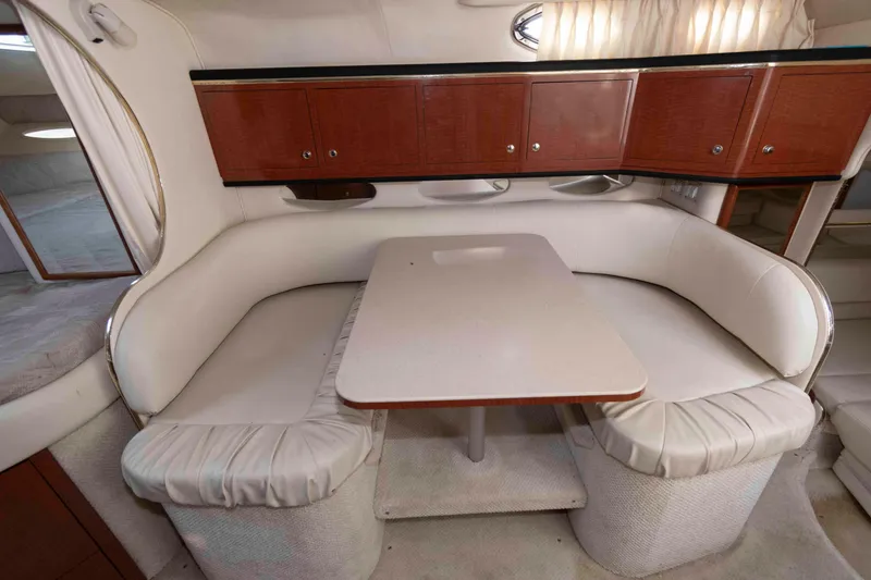 Slide: The Image of Interior of 2002 Sea Ray Sundancer 310 with cozy dining area and wooden cabinets. - 10