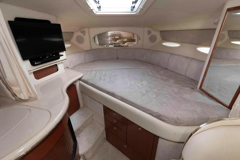 Slide: The Image of 2002 Sea Ray Sundancer 310 cabin interior with bed, TV, and storage cabinets. - 11