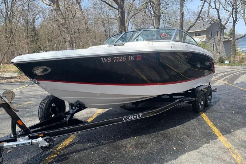 Slide: The Image of 2015 Cobalt R3 boat on trailer in wooded area, black and white design. - 5