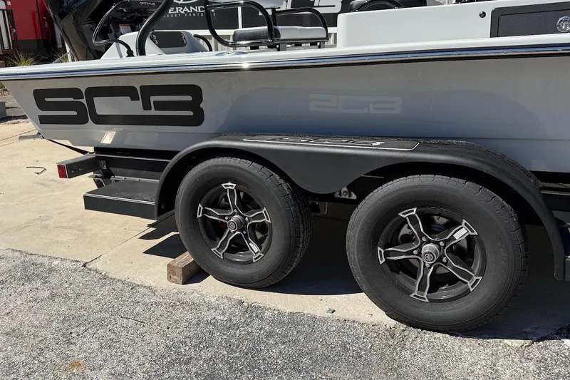 Slide: The Image of 2026 SCB R24 boat on trailer with dual wheels, parked outdoors. - 10