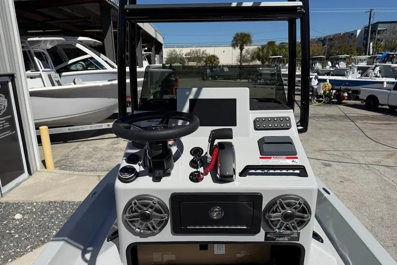 Slide: The Image of 2026 SCB R24 boat console with steering wheel, controls, and speakers in a marina setting. - 15