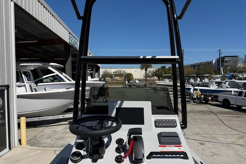 Slide: The Image of 2026 SCB R24 boat console with steering wheel and controls, docked near other boats. - 16