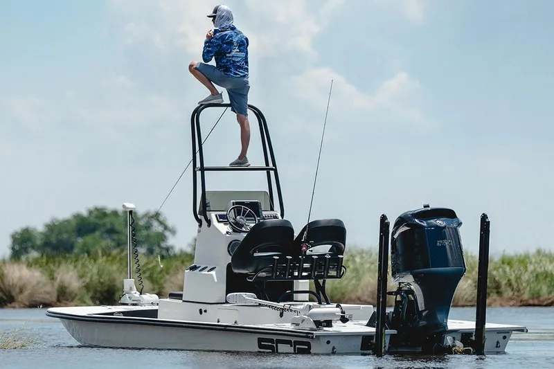 Slide: The Image of Manufacturer Provided Image: 2026 SCB R24 boat with elevated platform, person observing, powerful outboard motor, calm water. - 5
