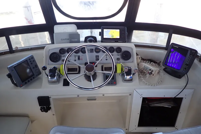 Slide: The Image of 1988 Mainship boat helm with steering wheel, navigation equipment, and control panels. - 10