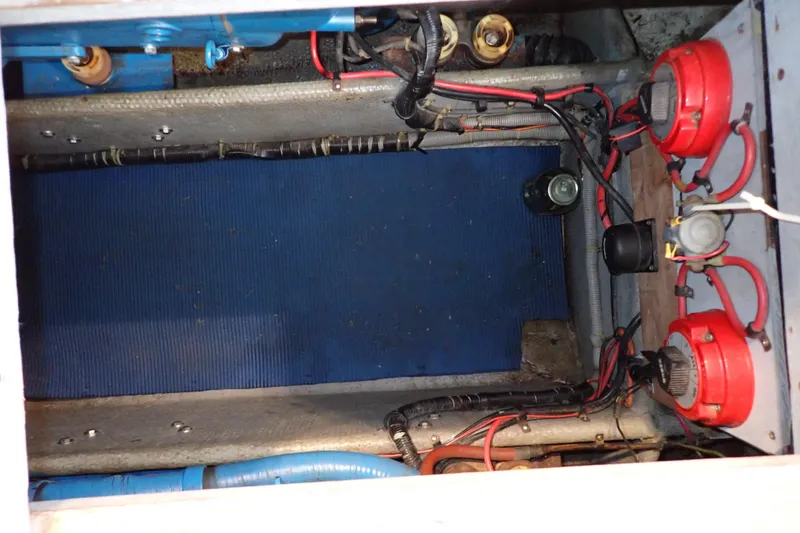 Slide: The Image of 1988 Mainship boat engine compartment with wiring and red components. - 102