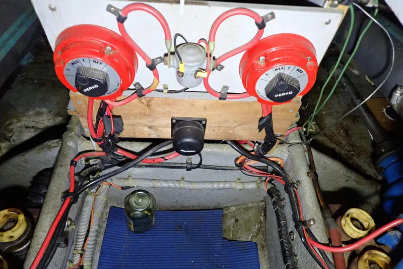 Slide: The Image of 1988 Mainship boat electrical system with red battery switches and wiring. - 103