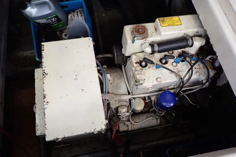 Slide: The Image of 1988 Mainship engine compartment with visible components and maintenance supplies. - 105