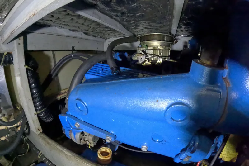 Slide: The Image of 1988 Mainship engine compartment with blue machinery and hoses. - 108