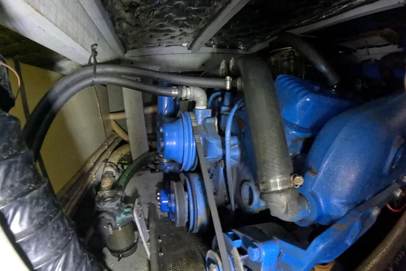 Slide: The Image of 1988 Mainship engine compartment with blue components and hoses. - 112