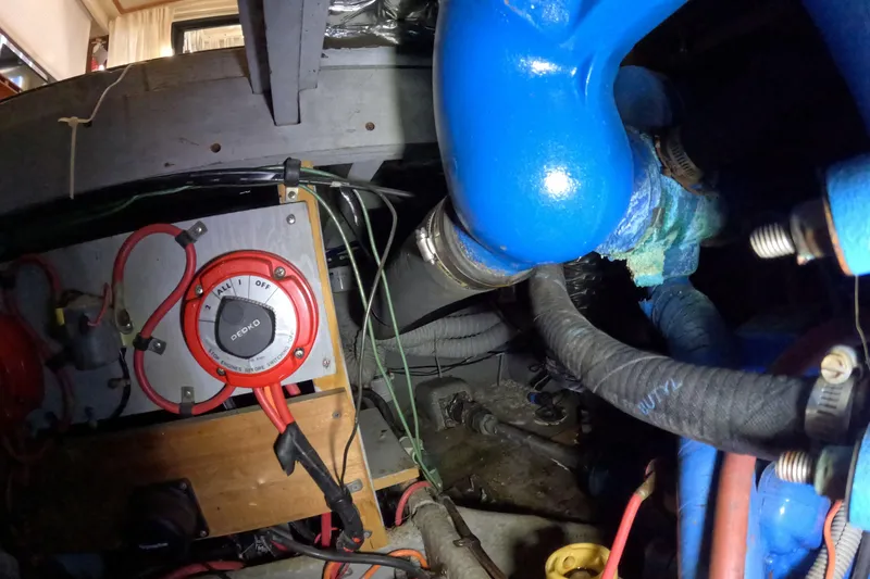 Slide: The Image of 1988 Mainship engine compartment with battery switch and blue hoses. - 116