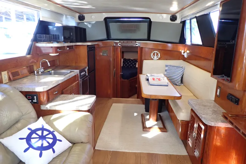 Slide: The Image of 1988 Mainship boat interior with kitchen, seating area, and nautical decor. - 12