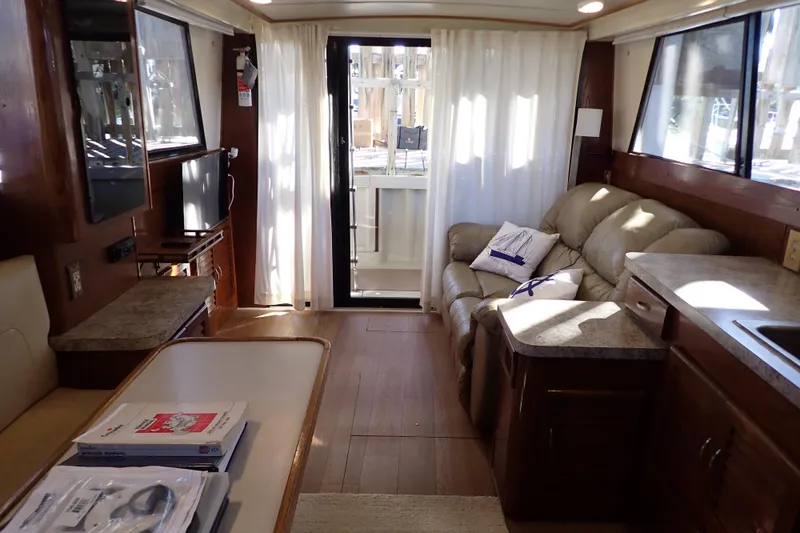 Slide: The Image of Interior of a 1988 Mainship boat with cozy seating, table, and natural light. - 13