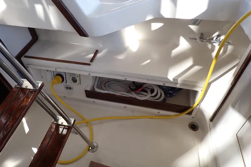 Slide: The Image of 1988 Mainship boat interior with yellow power cable and storage compartment. - 32